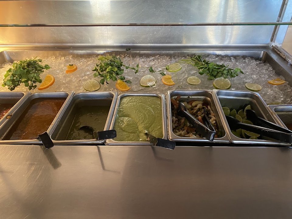 Printed menu with burritos, tacos, and salads.
