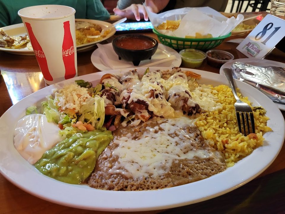 Printed menu with burritos, tacos, and salads.