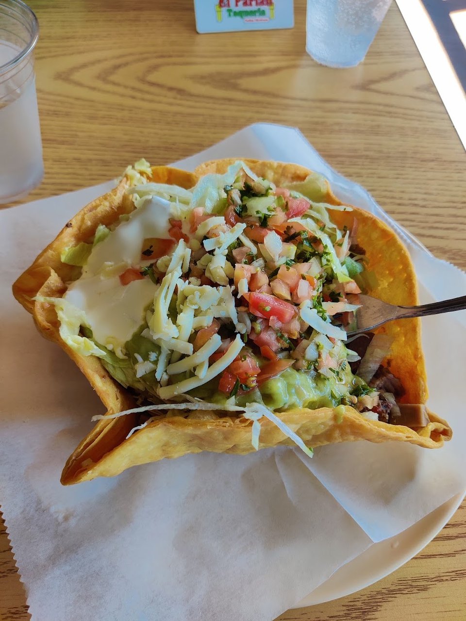 Printed menu with burritos, tacos, and salads.